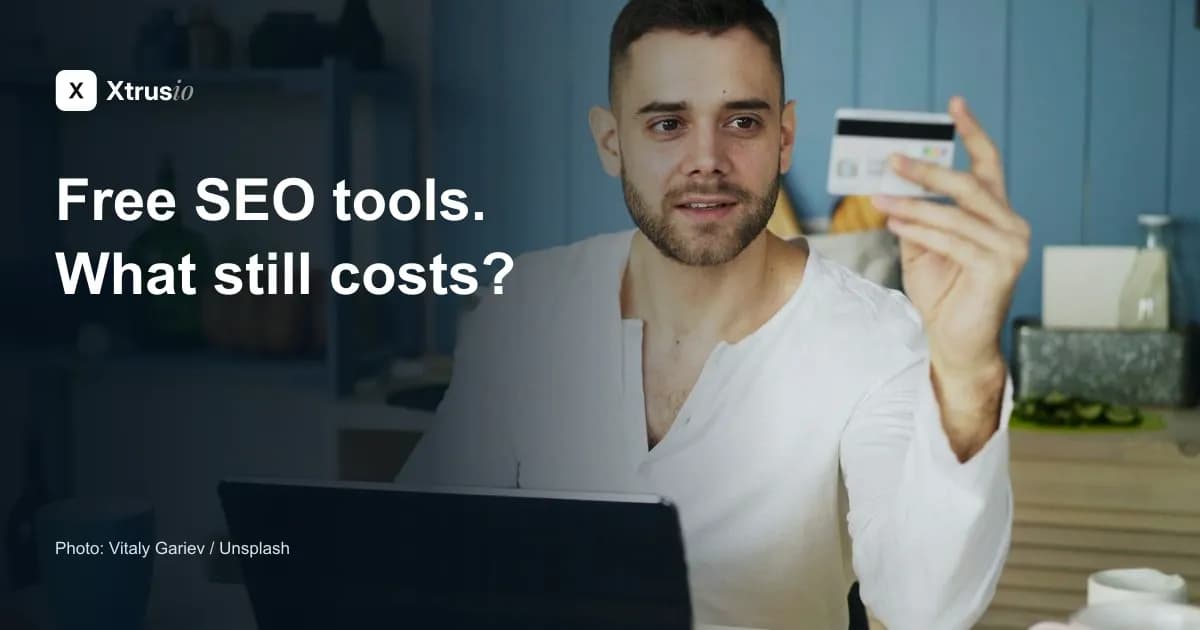 Licensed photograph of a man considering a payment card beside a laptop